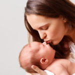 closeup-portrait-winsome-woman-kissing-her-newborn-baby-with-closed-eyes-scaled.jpg
